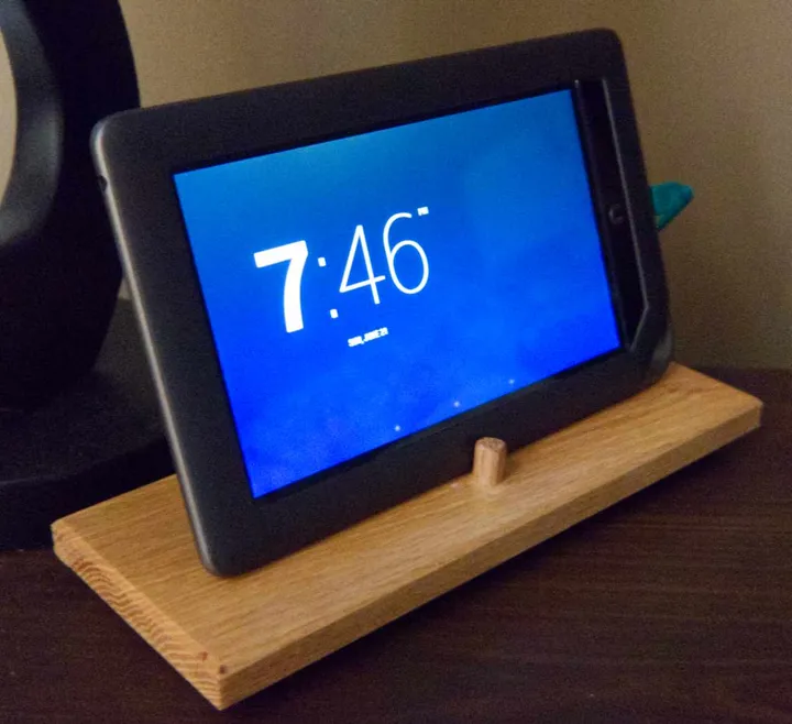 Old tablet on a nightstand showing a clock